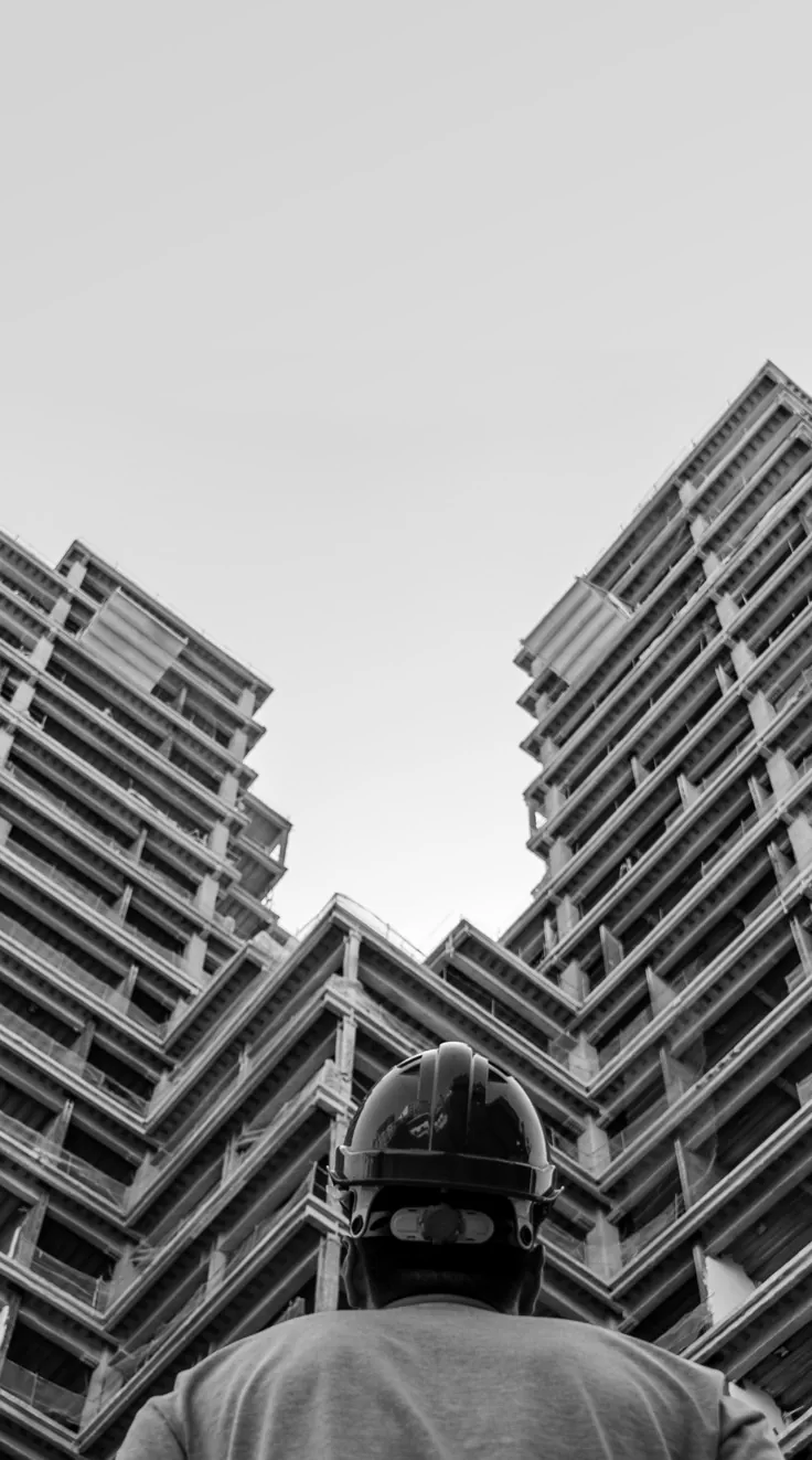 Site engineer looking up at a residential tower under construction